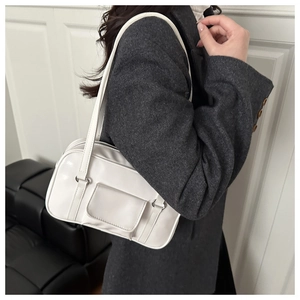 White minimalist PU leather shoulder bag with decorative flap pocket shown on a model