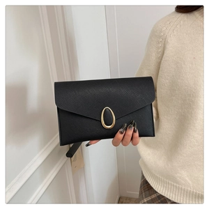 Détail d'une pochette enveloppe en cuir Saffiano noir avec boucle en métal doré