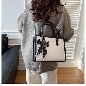 Détail du sac cabas à motif peau de serpent avec foulard en soie décoratif à cœurs