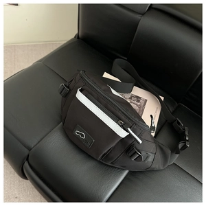 Close-up of black crossbody chest bag featuring a safety reflective strip and zippers
