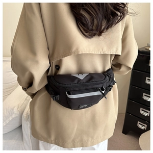 Detail of black waterproof nylon waist bag featuring gray reflective safety strips on back