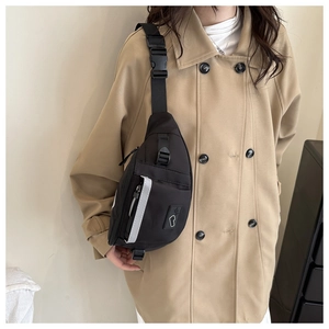 Detail of black nylon chest bag showing reflective strip and adjustable buckle strap