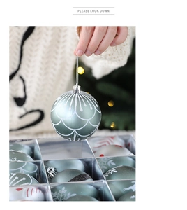Close-up of Morandi green and white Christmas balls with hand-held festive ornaments