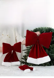 Détail d'un nœud de Noël en velours rouge avec bordure en fausse fourrure sur un sapin