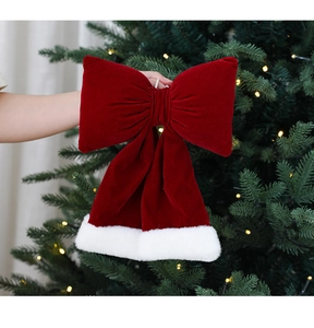 Détail d'un nœud de Noël en velours rouge avec bordure en fausse fourrure blanche