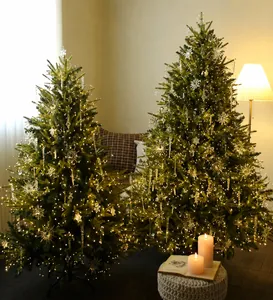 Detailed view of decorated Christmas trees with warm LED lights and snowflake pendants