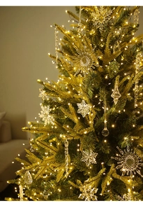 Detalle de copos de nieve transparentes y luces LED cálidas en un árbol de Navidad