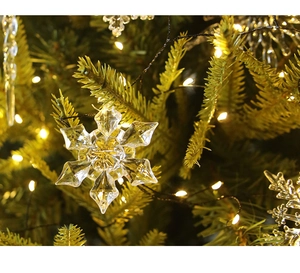 Primer plano de adornos de copo de nieve de cristal colgando de un árbol de Navidad real