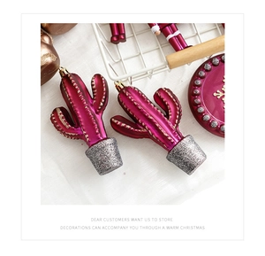 Detail of pink cactus-shaped Christmas ornaments with silver glitter and metallic finish