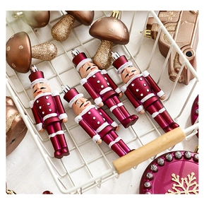 Detail of nutcracker and mushroom Christmas ornaments in a white metal basket
