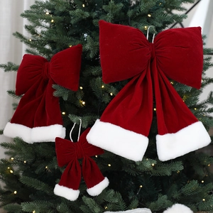 Noeuds de Noël en velours rouge avec bordure en fourrure blanche sur un sapin décoré