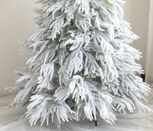 Close-up of premium snow flocked Christmas tree with dense needles and metal base