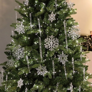 Adornos transparentes de copos de nieve y carámbanos en un árbol de Navidad iluminado