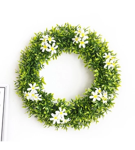 Gros plan d'une couronne de printemps avec des feuilles vertes et de petites fleurs