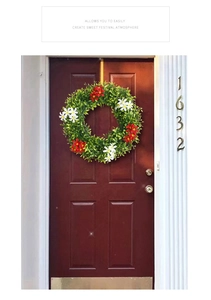 Detailed view of artificial spring wreath with red and white flowers on a wooden door