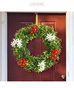 Close-up of spring wreath with green leaves and red plumeria on a rustic wooden door
