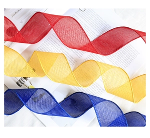 Detailed texture of red, yellow and blue faux linen mesh ribbons for festive DIY decor