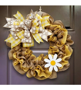 Detail of rustic burlap wreath with yellow mesh and daisy bow for front door decoration