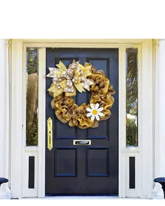 Detail of burlap wreath with yellow plaid bow and daisy flower on a blue front door