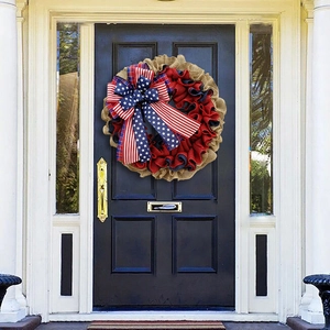 Detail van jutekrans met Amerikaanse vlagstrik hangend aan een donkerblauwe voordeur