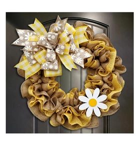 Detail showing the rustic burlap texture and floral bow of the decorative bee wreath