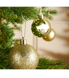 Primo piano di palline di Natale dorate con finiture glitter e opache sull'albero