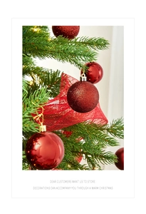 Primo piano di palline di Natale rosse lucide e glitterate appese a un ramo di pino