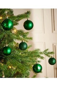 Dettaglio di palline di Natale verde scuro con finiture opache e glitterate sull'albero