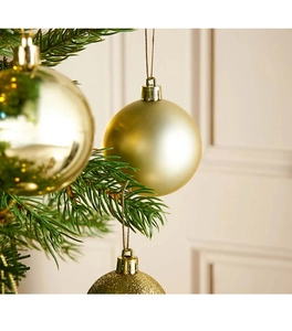 Dettaglio di palline di Natale dorate con finiture glitter, opache e lucide sull'albero