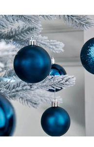 Dettaglio di palline di Natale da 8 cm blu scuro opache e lucide su rami di pino innevati