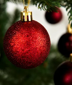 Detailed view of 8cm wine red glitter Christmas ball with gold hanging string and cap