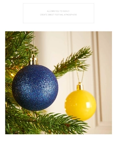 Dettaglio di palline di Natale blu glitterate e gialle lucide appese ai pini