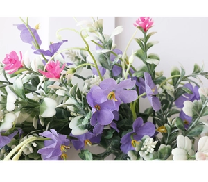 Detailed close-up of vibrant pink and purple faux wildflowers with realistic green silk leaves