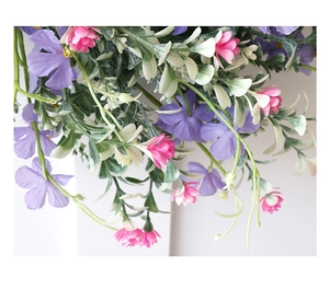 Close-up of artificial spring wreath with lavender flowers and greenery for home decor
