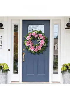 Detail of pink rose and eucalyptus artificial wreath hanging on a dark blue front door