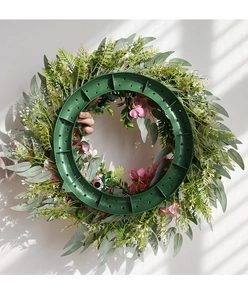 Detail of the green plastic ring frame structure on the back of the pink rose wreath
