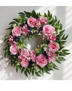 Close-up of pink rose and eucalyptus wreath showing realistic petals and lush green leaves