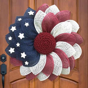 Patriotic July 4th sunflower wreath with red white and blue mesh on a dark wooden door