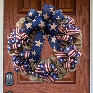 Detail of burlap Fourth of July wreath with patriotic star and stripe ribbons on front door