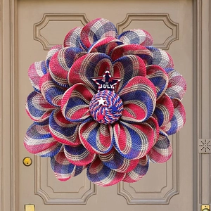 Detail of red white and blue July 4th patriotic wreath with star on brown wooden door