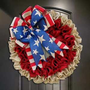 Close-up of patriotic 4th of July burlap wreath detail on a black textured door