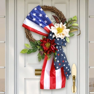 Patriotic July 4th flag wreath with red and white flowers hanging on a white door