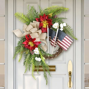 Detail of US Independence Day wreath with burlap bow and mini flags on white wooden door