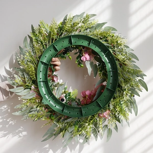 Artificial eucalyptus wreath with pink roses and black berries on round plastic base
