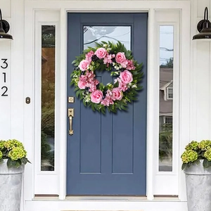 Pink rose and eucalyptus artificial wreath hanging on a blue wooden door for home decor