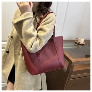 Gros plan d'un cabas en cuir PU bordeaux avec texture de lychee et détails de couture fins