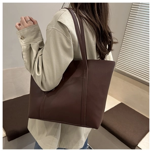 Detail of chocolate brown PU leather tote bag with smooth texture and vertical stitching