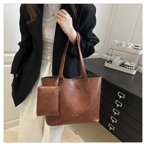 Detail of vintage brown oil wax leather tote bag with a small matching pouch and logo