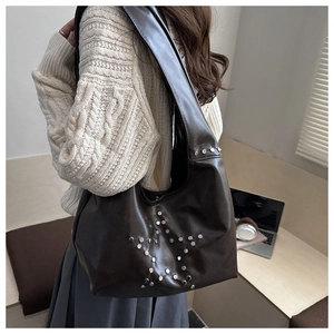 Detail of dark brown hobo bag with silver star rivets and comfortable wide shoulder strap