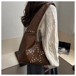 Detailed view of silver star rivets on dark brown vintage hobo shoulder bag
